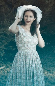 Young woman gardening with elegant summer hat