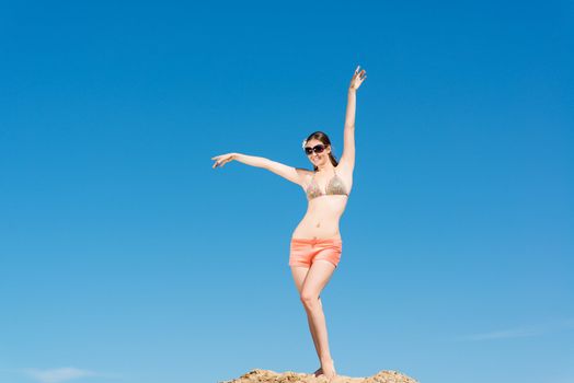 beautiful woman spread her arms against the blue sky, a good time