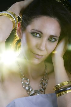 Beautiful woman with evening make-up. Jewelry and Beauty. Yellow light