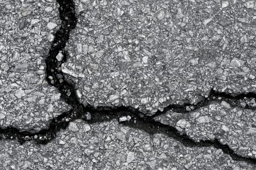 Old worn and cracked asphalt with cracks