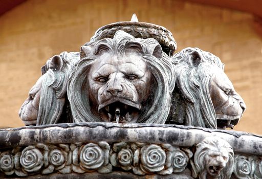 Fountain in a form of big and old lion statue and flowers