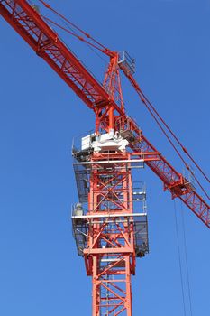 Red building crane on blue sky