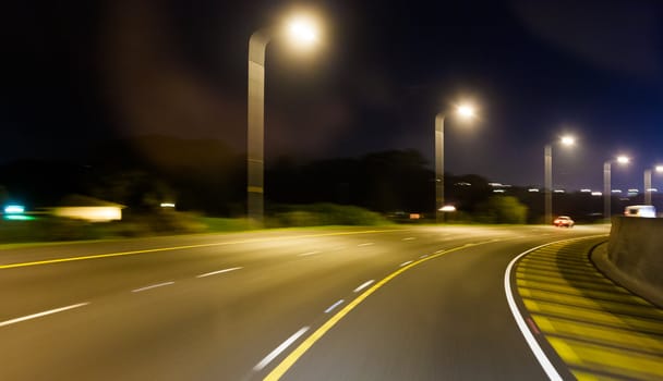 Highway speed blur at dusk with street lights