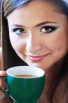 a close up portrait of a brunette drinking coffee