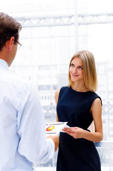 male and female entrepreneurs working together, discuss reports