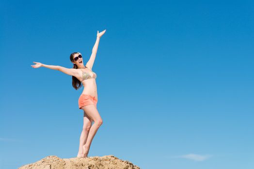 beautiful woman spread her arms against the blue sky, a good time