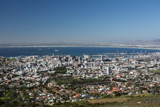 Aerial view of the city of Capetown showing the densely packed buildings and clear blue water in the background