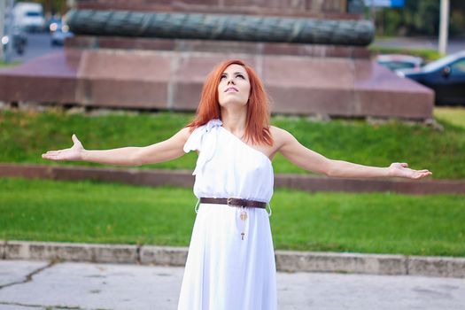 Portraite of a redhead girl raising her hands 