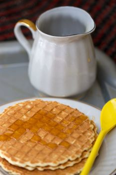 Round wafers with a long spoon and honey