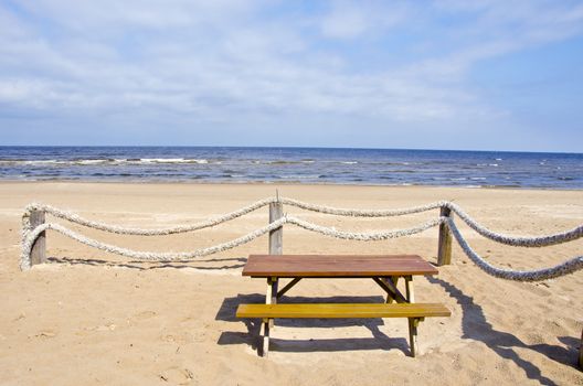 summer sea beach with ropes fence and cafe table