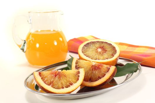 red-yellow blood orange with leaves and juice on a light background