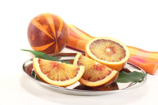 red-yellow juicy blood orange with leaves and napkin on a bright background