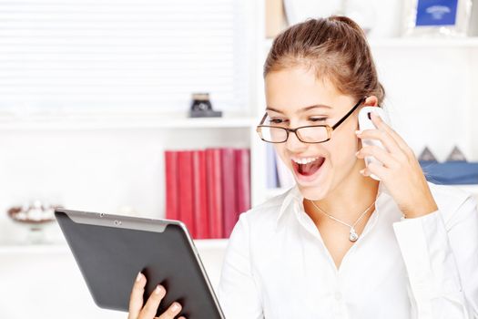 Young happy businesswoman looking at tablet computer