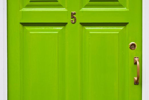 green typical residential house door in Ireland (number 5, golden lock and handle)