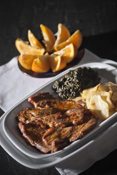 Real food photographed on location in traditional portuguese restaurants, pork fillet seasoned with red bell pepper garnished with mashed spinach, Alentejo, Portugal