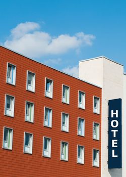facade of a modern red brick Hotel building with sign