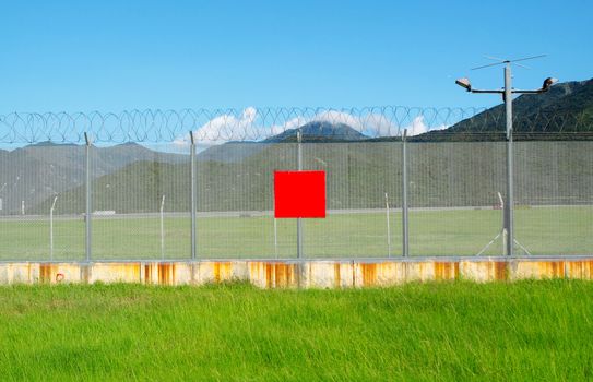 metal fence in the nature and red board for text