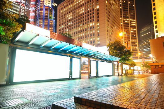 Blank billboard on bus stop at night 