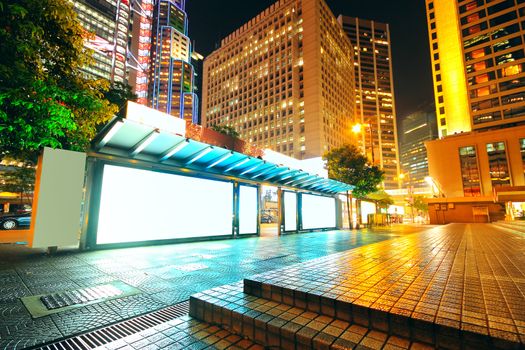 Blank billboard on bus stop at night 