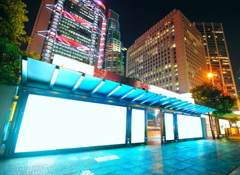 Blank billboard on bus stop at night 