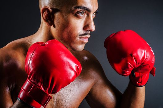 Boxer with red gloves in dark room