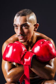 Boxer with red gloves in dark room