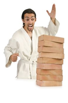 Karate man breaking bricks on white