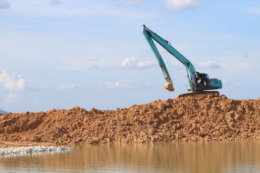 Excavator located by a river and ready for work