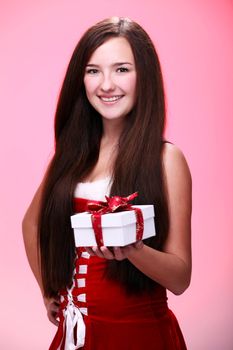 Portrait of young and beautiful christmas girl in red with gift