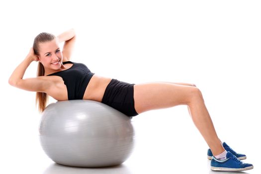 Beautiful and smiling woman doing abs exercises with fitness ball over white background