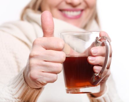 Mid age Woman With Hot tea Wearing Winter Clothes showing thumbs up on a white background