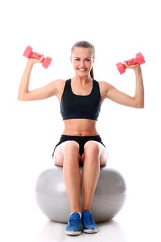 Beautiful and smiling woman doing exercises with dumbells on fitness ball over white background