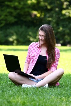 Young and beautiful woman with laptop in park