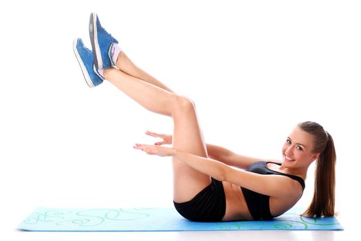 Happy girl doing fitness exercises on a mat over white background