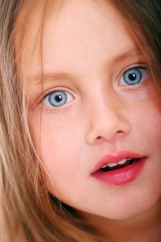 Close up of little girl with big eyes looking at you