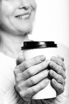 Black and white close up of midlle aged woman with coffee on a white background