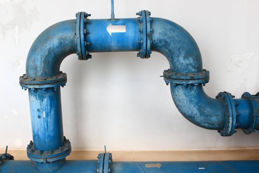 blue pipe line with blue valve on  wall