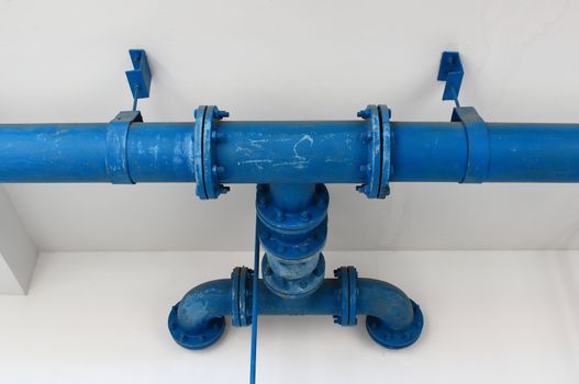 blue pipe line with blue valve on  wall