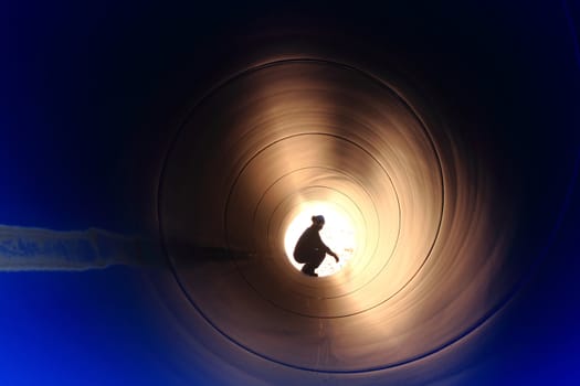 A silhouette of a worker in pipe