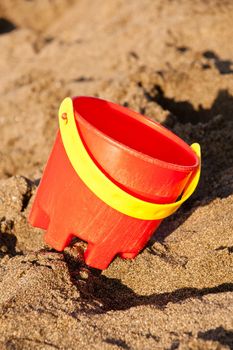 Unorganized colorful plastic beach toys on sand .