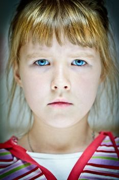 Facial portrait of a caucasian girl with blue eyes and straw-colored hair 