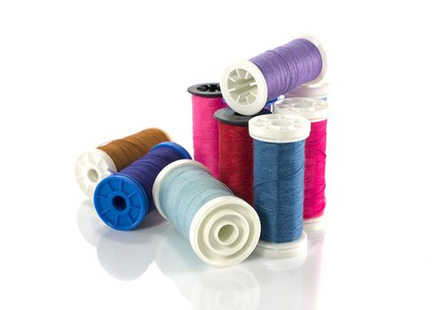 stack of coloured sewing thread isolated on white
