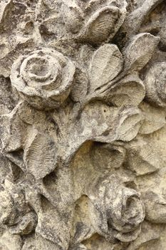 roses flowers and leaves carved in stone at a grave