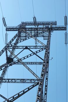 Power lines and electricity pylon  against blue sky