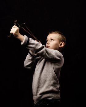 Little boy shooting with a slingshot