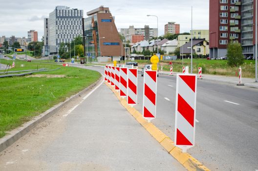 warning signs on the roadside near new road construction to residential area