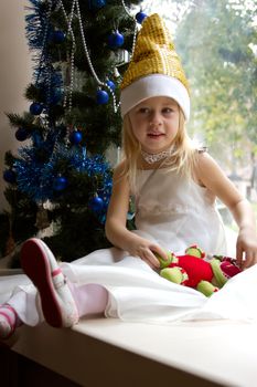 Portrait of happy girl in Santa cap  Christmas tree