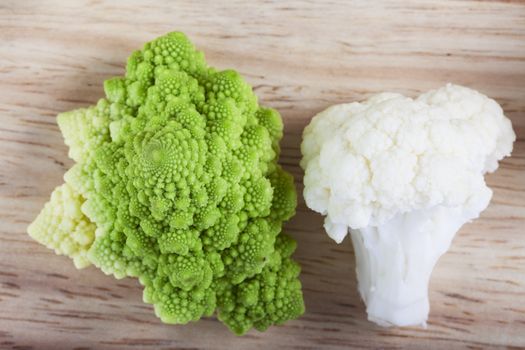 Fresh cauliflower and romanesco broccoli on board