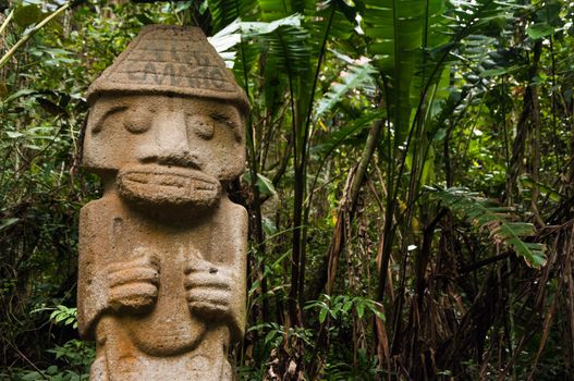 An ancient statue that has been vandalized and painted with graffiti.