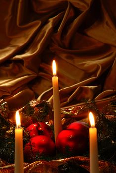 Candles and Christmas balls on a gold background